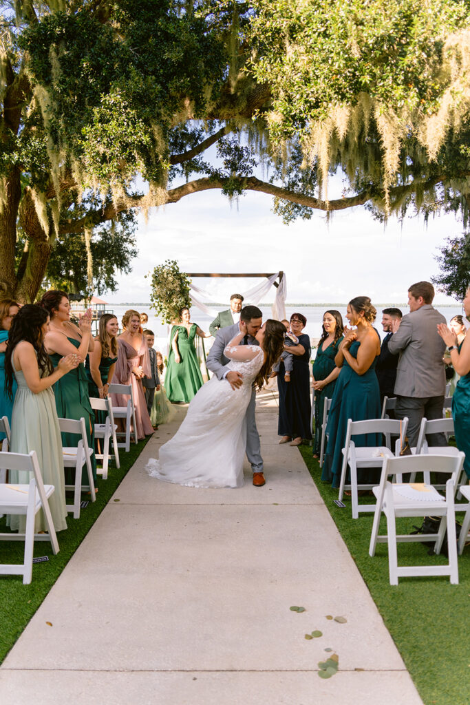 stunning couple kissing at the close of their wedding ceremony at Bella Cosa Estate in Lake Wales florida, photographed by Florida wedding photographer as a part of the best wedding photographer florida